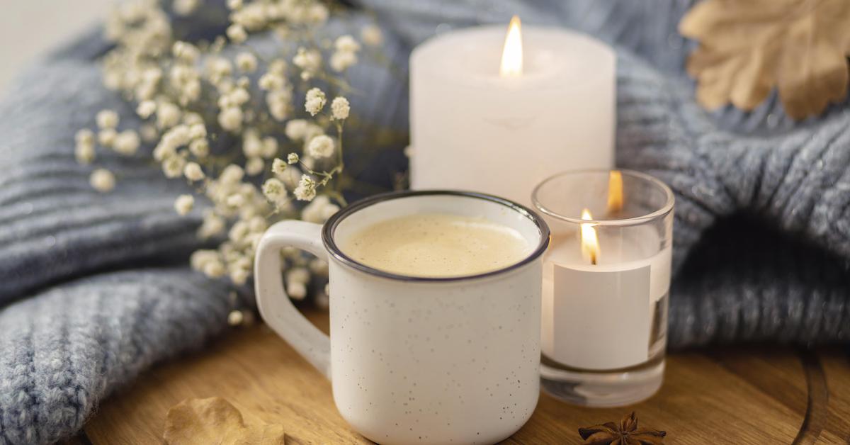 high-angle-lit-candles-with-cup-coffee-sweater