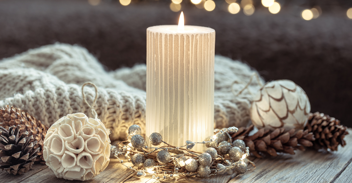 winter-festive-background-with-burning-candle-home-decor-details-blurred-background-with-bokeh
