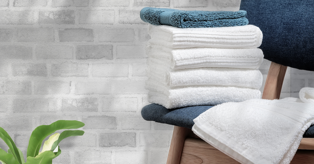 clean-terry-towels-wooden-chair-with-brick-wall-background-copy-space