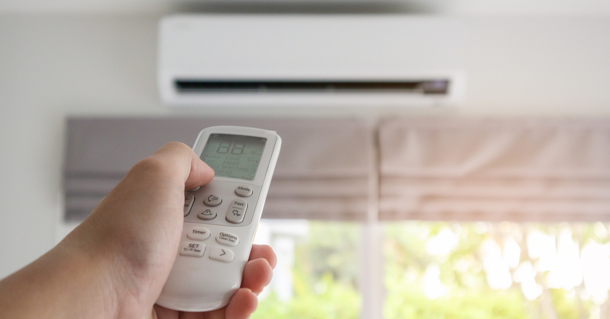 hand-with-remote-control-directed-air-conditioner