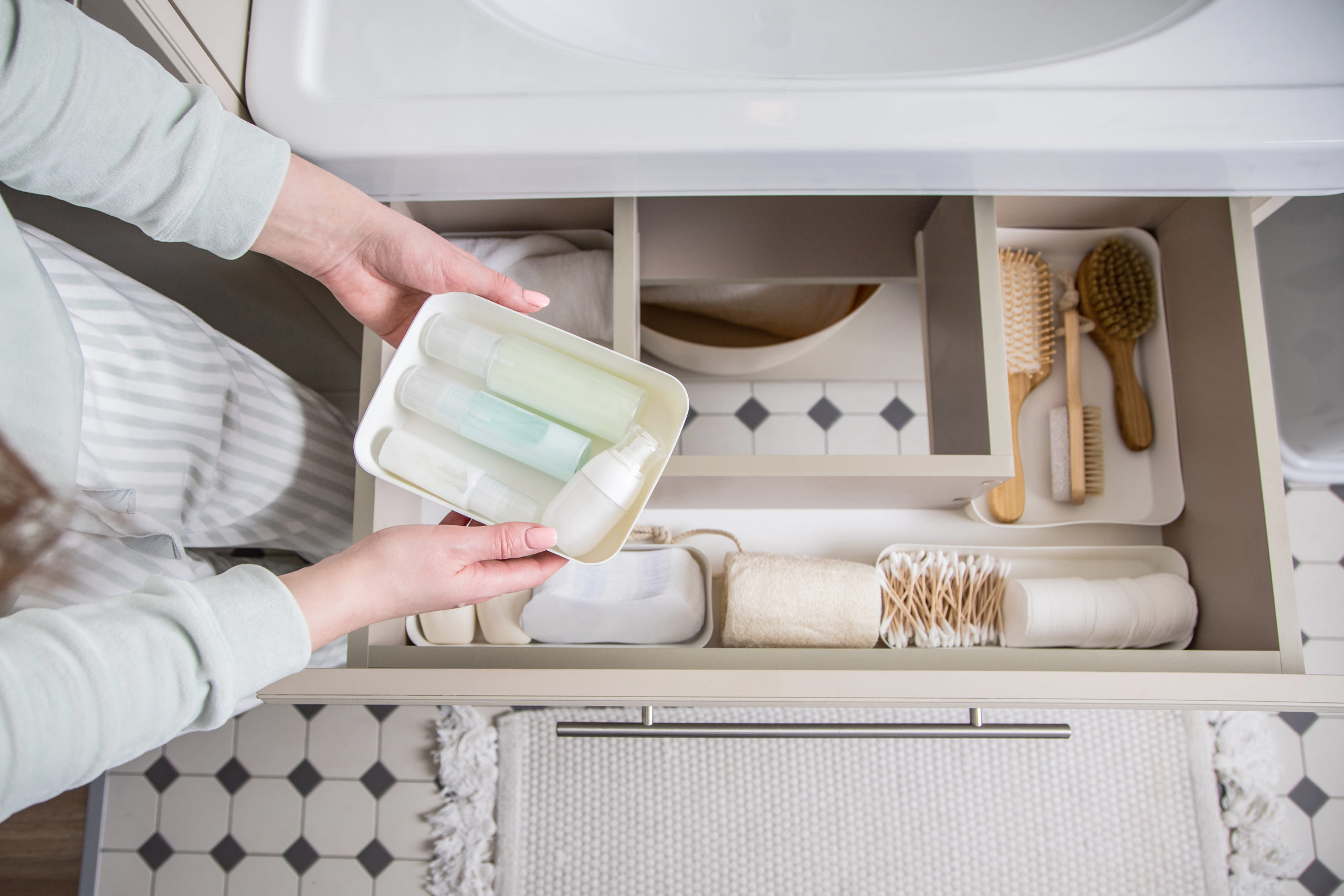 housewife-hands-putting-rolled-up-towel-into-drawer-sink-organizing-storage-space-bathroom-scaled